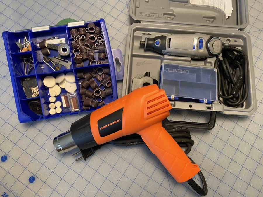 Dremel tool and accessories and an orange heat gun